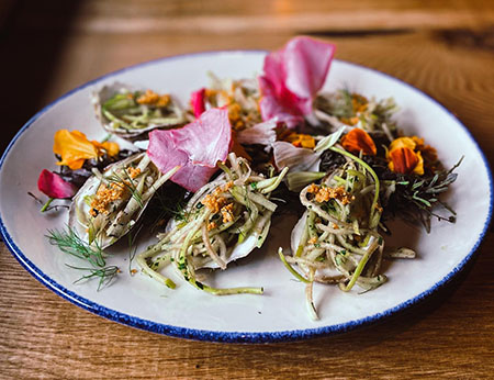 Healthy grilled oysters with kohlrabi slaw and fresh herbs and edible flowers from the garden at Sylvan Table in Sylvan, MI