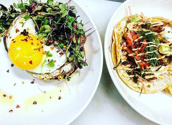 Healthy greens-topped breakfast benedicts and handheld tacos all-day at 2 Birds family-owned local cafe in Miramar Beach, FL