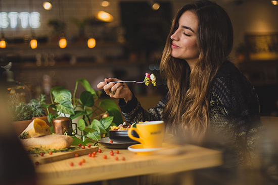 A woman savoring food while practicing mindful eating for health and pleasure