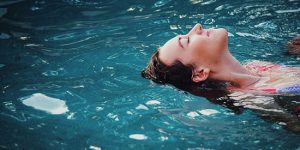 Woman mindfully and joyfully relaxing in a pool