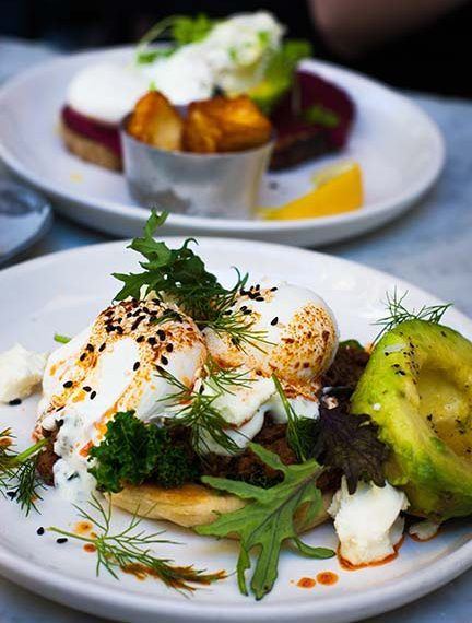 organic pasture-raised poached eggs atop greens with avocado make a satisfying breakfast